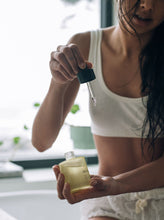 Load image into Gallery viewer, Woman applying hair and body oil to skin